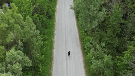 Top-View-Of-A-Man-Running-Across-The-Empty-Country-Road