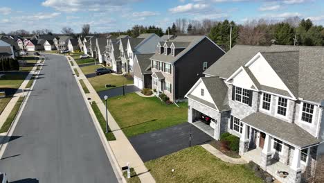 Angled-aerial-dolly-above-peaceful-subdivision-of-large-homes,-sunny-day