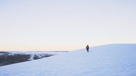 Mann-In-Winterkleidung-Läuft-Frei-Einen-Schneebedeckten-Hügel-In-Offener-Landschaft-Hinauf