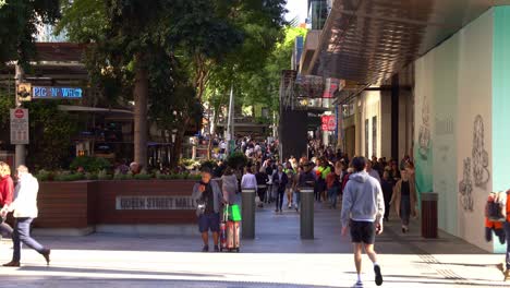 Large-crowds-of-people-in-bustling-downtown-Brisbane-city,-strolling-and-shopping-at-iconic-Queen-street-mall,-outdoor-pedestrian-shopping-mall-on-a-sunny-day,-static-shot