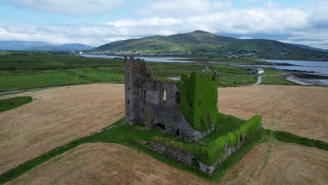 Aerial-circle-of-ivy-covered-Ballycarbery-Castle-near-the-Ocean,-Cahersiveen,-Ireland