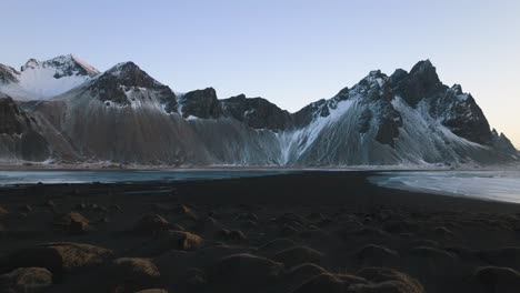 Vista-Aérea-Sobre-La-Playa-De-Stokksnes,-Hacia-La-Montaña-Nevada-De-Vestrahorn,-Puesta-De-Sol-En-Islandia