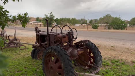 An-antique,-vintage-tractor-in-a-in-a-farmland-field---rack-focus-reveal