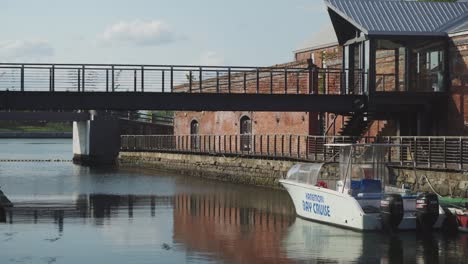 Empty-Hakodate-Small-Cruise-Boat-Docked-In-Marina-With-Bridge-Walkway-In-View