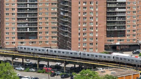 New-York-City-subway-train-passing-in-front-of-tall-residential-apartment-buildings-in-NYC