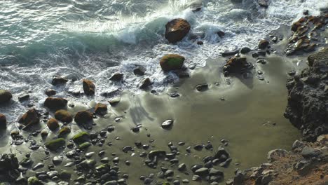 Ocean-waves-washing-rocky-sandy-beach-of-Tenerife-coast,-top-down-view