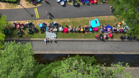 Drohnenansicht-Einer-Großen-Gemeinde,-Die-Sich-An-Einem-Sonnigen-Sommertag-In-Einem-Park-Versammelt-Hat