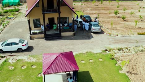 Aerial-shot-of-people-meeting-and-greeting-in-front-of-a-Farmhouse-in-Rural-Punjab