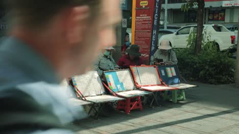 Thai-Lottery-Sellers-Sitting-Down-with-Tickets-on-Show-in-Bangkok,-Thailand