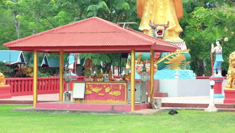 Adornos-Budistas-Tailandeses-Con-Estatua-En-El-Fondo-En-Wat-Kut-Khla,-Khao-Yai