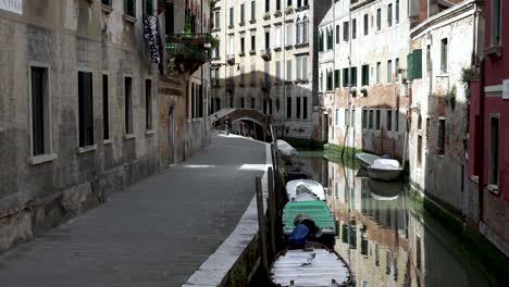 Row-Of-Empty-Boats-Moored-Beside-Canal-In-Venice