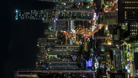 Colorful-Surfer's-paradise's-city-skyline-at-nighttime---vertical-aerial-hyper-lapse