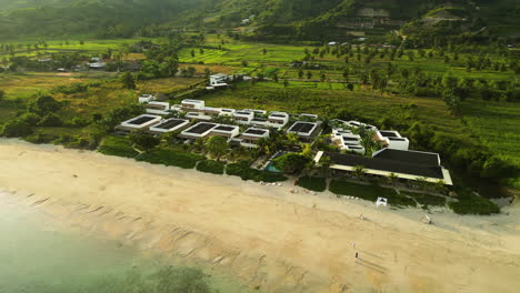 Aerial-View-of-a-Luxurious-Resort-Amidst-Beach-and-Farmland-in-Rural-Countryside