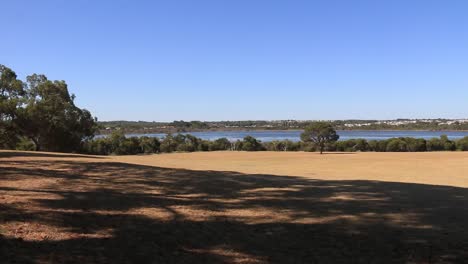 Panning-shot-left-to-right-of-Joondalup-Lake-and-blue-sky-beyond-trees