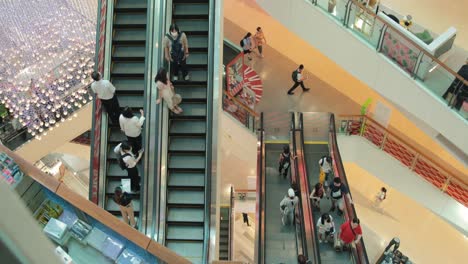 Gente-Parada-En-Escaleras-Mecánicas-Moviéndose-Entre-Pisos-En-Un-Centro-Comercial-En-Bangkok,-Tailandia