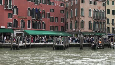 Blick-Auf-Die-Anlegestelle-Der-Gondel-Neben-Dem-Rialto-Fährterminal-Am-Canal-Grande-In-Venedig-Mit-Geschäftigen-Menschenmassen-Im-Hintergrund