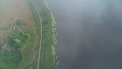Vogelperspektive-Zwischen-Den-Wolken-über-Einer-Grünen-Landschaft-Am-Rande-Eines-Sees