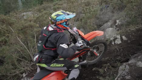 Piloto-De-Motocross-Esforzándose-Por-Subir-Una-Colina-Alta-En-El-Suelo