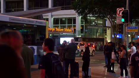 Large-crowds-of-commuters-waiting-at-the-traffic-lights,-crossing-the-road-on-Albert-and-Adelaide-street-in-Brisbane-city-towards-King-George-Square-busway-station,-bus-interchange