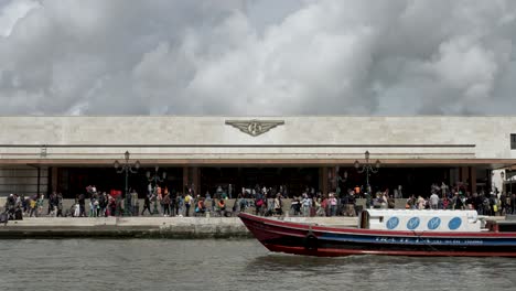 Vista-De-La-Estación-De-Tren-De-Venecia-Santa-Lucía-Desde-El-Otro-Lado-Del-Gran-Canal-Con-Un-Barco-Pasando