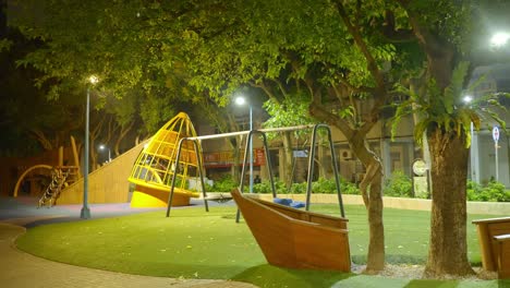 Leerer-Spielplatz-Mit-Tropischem-Baum-Und-Holzbootausrüstung-In-Taiwan-Bei-Nacht