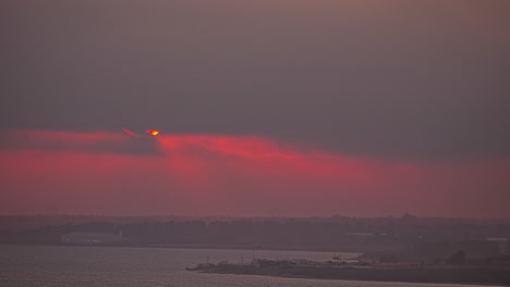 Ein-Orangefarbener-Sonnenuntergang-über-Dem-Meer-Ist-Von-Dunklen-Wolken-Bedeckt