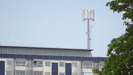 5G-Mobilfunkmast-Erhebt-Sich-über-Dem-Gebäude-In-Einer-Teleaufnahme,-Dalarna