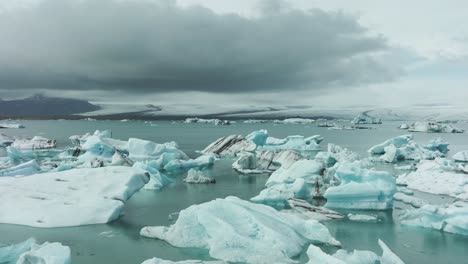 Flying-Above-Icebergs-in-Glacial-Lagoon,-Breathtaking-Landscape-of-Iceland,-Drone-Shot