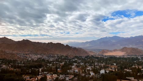 Vista-Frontal-De-Un-Pueblo-En-Jammu-Cachemira-Con-Muchos-Edificios-Residenciales-Y-árboles-Altos-Que-Lo-Rodean.