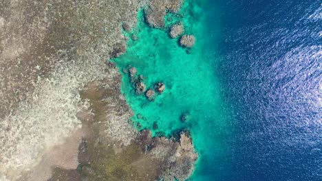 Aerial-drone-shot-of-crystal-clear-rocky-coastline-snorkel-diving-spot-coral-reef-inlet-water-ocean-holiday-trip-Hideaway-Mele-Island-Port-Vila-Vanuatu-4K
