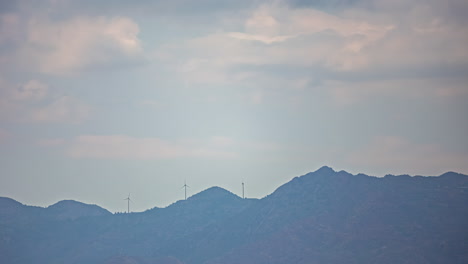 A-breathtaking-sight-of-wind-turbines-positioned-atop-majestic-mountains-adorned-with-picturesque-clouds