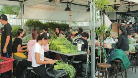 Gruppe-Von-Köchen,-Die-Auf-Dem-Jodd-Fairs-Market-In-Bangkok-Frisches-Gemüse-Zubereiten-Und-Schneiden