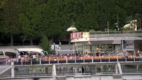 Bateaux-Mouches-river-cruise-loading-passengers-at-the-river-Seine,-Pan-right-shot