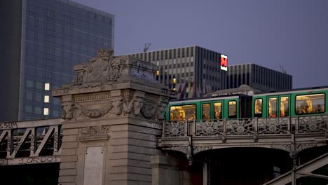 U-Bahn-Fährt-Nachts-über-Eine-Brücke-Mit-Passagieren-Darin,-Schwenk-Nach-Links,-Folgeaufnahme