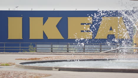 Yellow-and-blue-truck-drives-past-similarly-colored-IKEA-billboard,-tele-shot