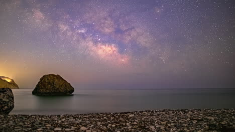 Pebbles-on-the-beach-at-Aphrodite's-Rock,-Cyprus-with-a-Milky-Way-time-lapse