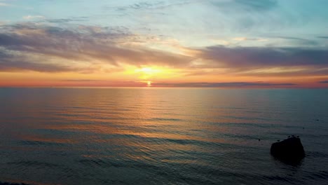 Luftaufnahme-Des-Wunderschönen-Goldenen-Sonnenuntergangs-über-Dem-Strand-Von-Pavilosta,-Lettland