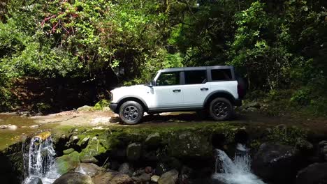 driving-ford-bronco-on-ballast-in-the-forest,-white-car