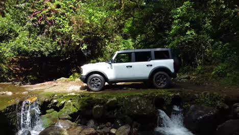 Ford-Bronco-Auf-Ballast-Im-Wald-Fahren,-Weißes-Auto