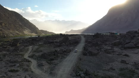 Drone-shot-of-a-vehicle-driving-on-a-dirt-road-in-the-Skardu-Valley-Pakistan