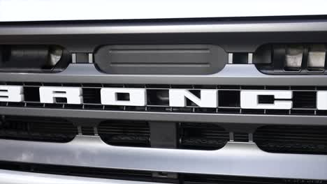 driving-ford-bronco-on-ballast-in-the-forest,-automotive-grill