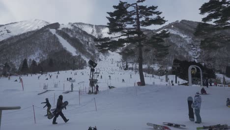 Ein-Zeitrafferbild,-Das-Die-Geschäftige-Atmosphäre-Des-Skigebiets-Hakuba-Bei-Hellem-Tageslicht-Einfängt,-Während-Skifahrer-Anmutig-Die-Pisten-Hinunterfahren