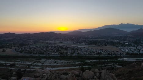 sunset-over-mt-rubidoux-in-riverside-california-with-bright-yellows-and-pinks-with-a-foggy-mountain-backdrop-AERIAL-DOLLY-FORWARD-RAISE