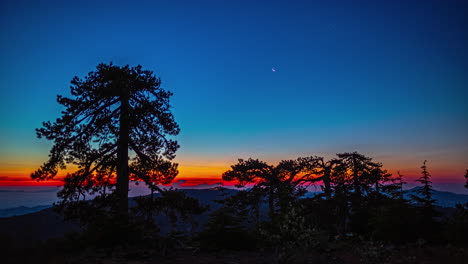 Stars-fade-in-the-predawn-sky-as-the-sunrise-lights-the-sky-from-Mount-Olympos,-Cyprus---time-lapse