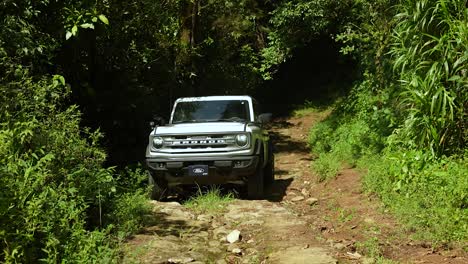 Conduciendo-Ford-Bronco-Sobre-Lastre-En-El-Bosque,-Coche-Blanco,-Bosque