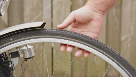 Hand-checking-flat-bicycle-tire