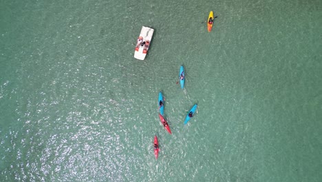 Aerial-overhead-birds-eye-view-group-of-canoes-and-single-pedalo-lake-Annecy-France