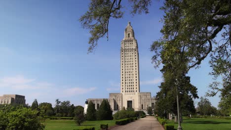 Louisiana-state-capitol-building-in-Baton-Rouge,-Louisiana-with-gimbal-video-walking-past-trees-in-slow-motion