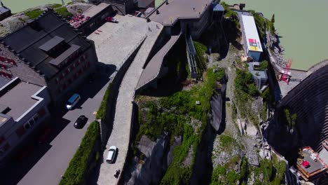 Aerial-drone-top-down-shot-over-roads-leading-to-Hotel-Grimsel-Hospiz-along-Grimsel-Pass,-Swiss-Mountain-in-Switzerland-on-a-sunny-day