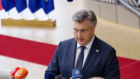 Prime-Minister-of-Croatia-Andrej-Plenković-giving-an-interview-during-the-European-Council-summit-in-Brussels,-Belgium---Close-shot